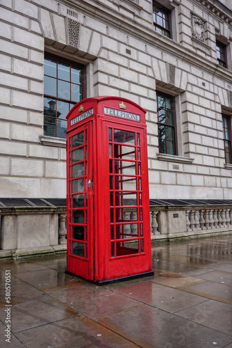 British telephone box in the capital city London. Vintage red phone booth. traditional pay phone kiosk 