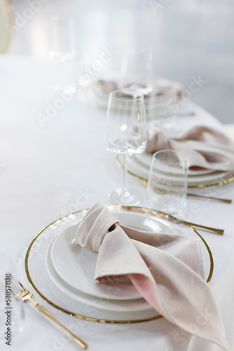 Plates, napkins and empty glasses on elegantly set table