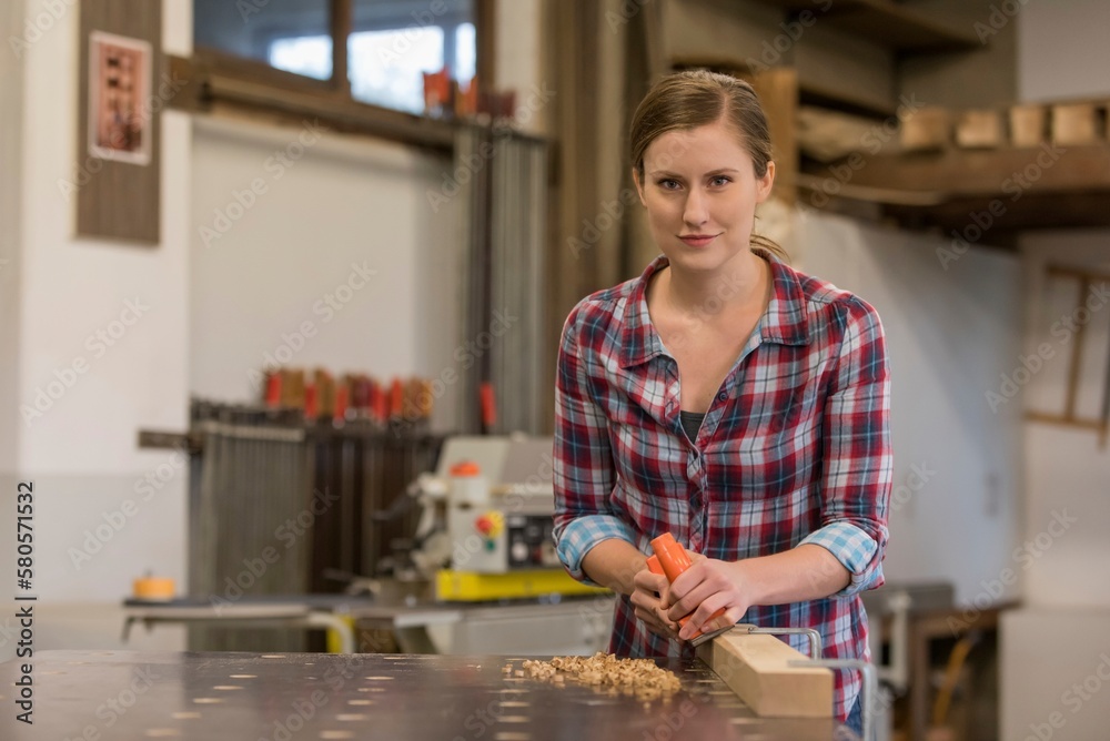 Young craftswoman working in woodshop Young craftswoman working in woodshop