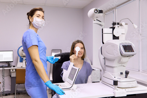Ophthalmologist performing vision diagnosis test on patient at clinic