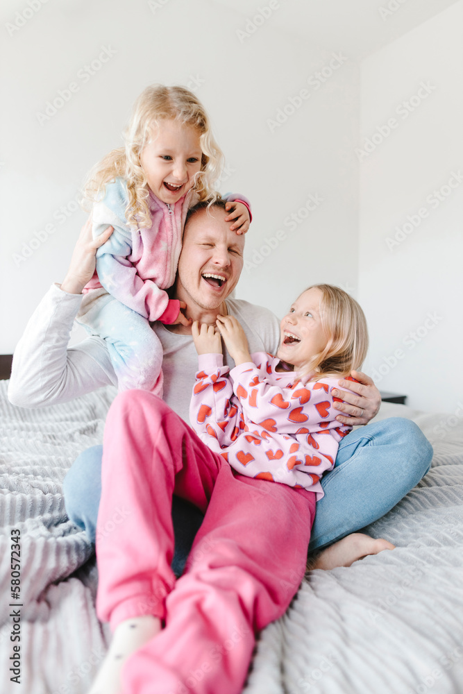 Cheerful father having fun with daughters at home Cheerful father having fun with daughters at home