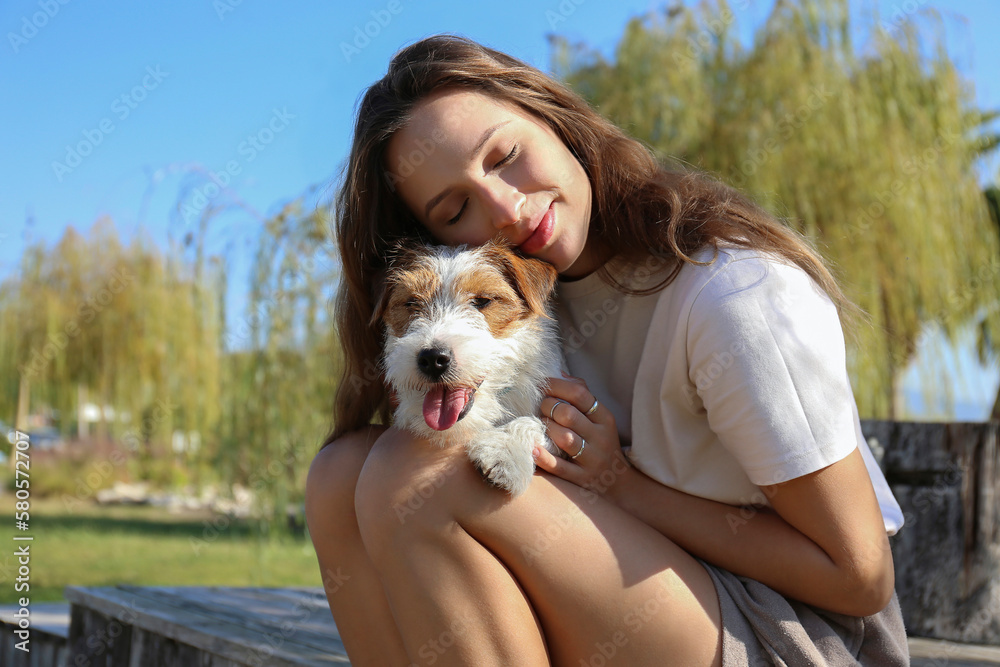 Young woman sitting with dog in park Young woman sitting with dog in park