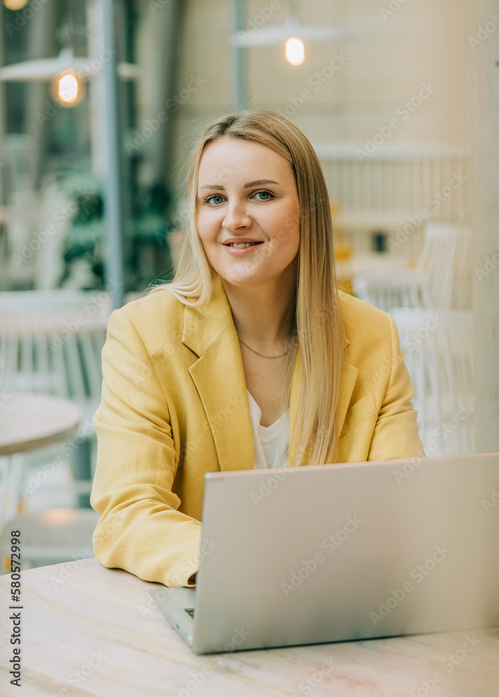 Smiling businesswoman with laptop sitting at cafe Smiling businesswoman with laptop sitting at cafe