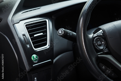 Economic green mode button in a modern car and part of a steering wheel and air conditioning system