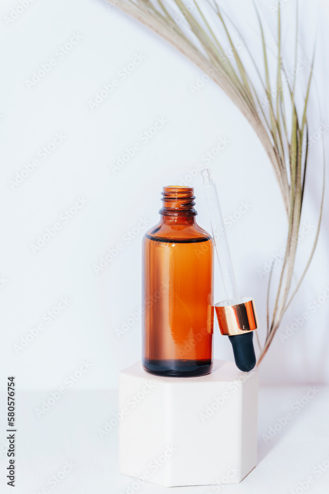 Brown serum bottle with pipette on a podium. Natural skin care cosmetics concept. Closeup Brown serum bottle with pipette on a podium. Natural skin care cosmetics concept. Closeup