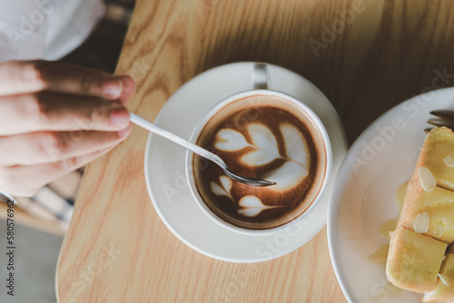 Hot cappuccino, vintage style coffee powder and coffee beans with green leaves On a black background 