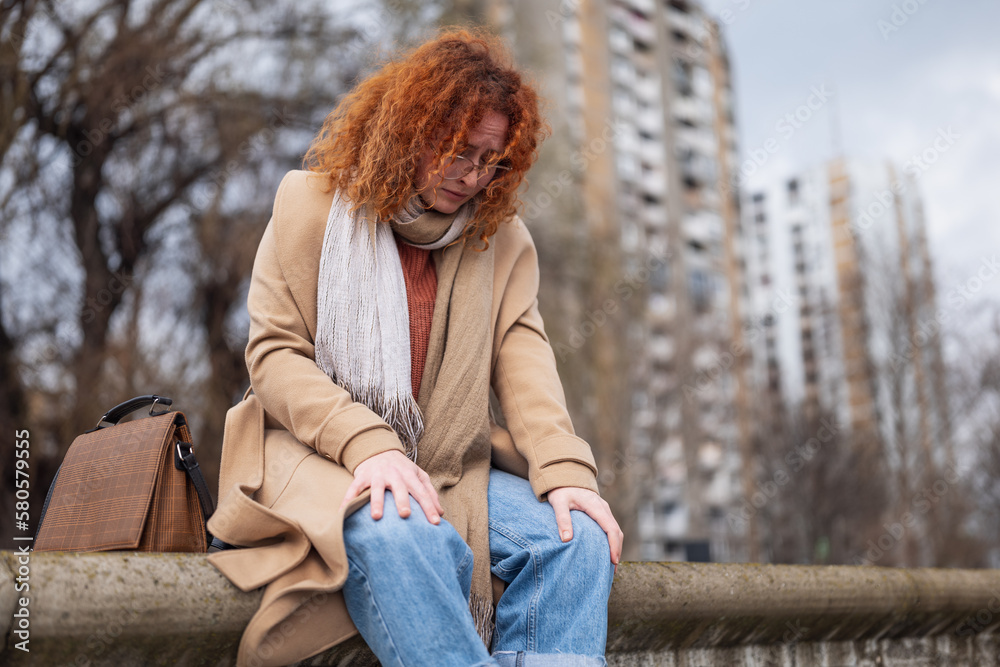 Natural portrait of a caucasian ginger woman with freckles and curly hair. She is depressed. Natural portrait of a caucasian ginger woman with freckles and curly hair. She is depressed.