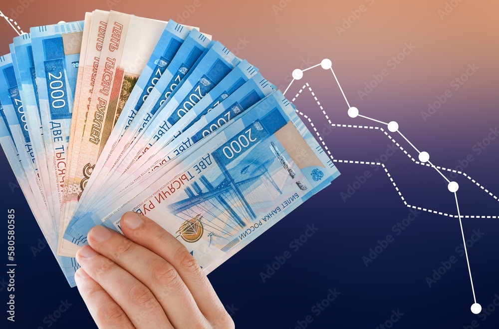 Fotografie Hand holding stack of currency note with digital trading chart.