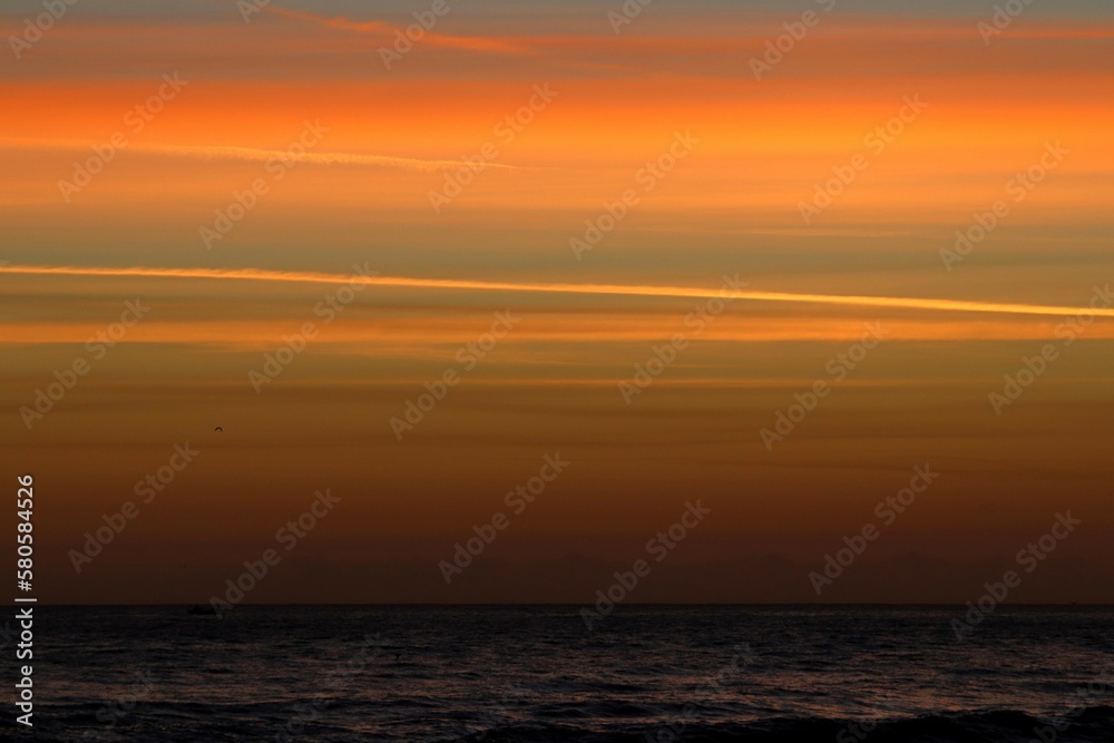 Sunrise over the ocean producing an orange and peach sky