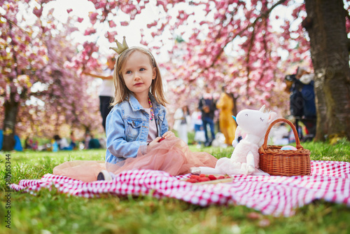 preschooler girl in tutu skirt enjoying nice spring day in cherry blossom garden © Ekaterina Pokrovsky