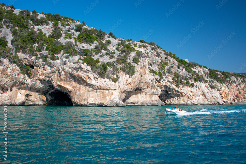 Mare blu e le caratteristiche grotte naturali di Cala Luna, Dorgali, Golfo di Orosei, Sardegna, Italia. Grandi grotte marine nella costa mediterranea. Sardegna, Italia.
