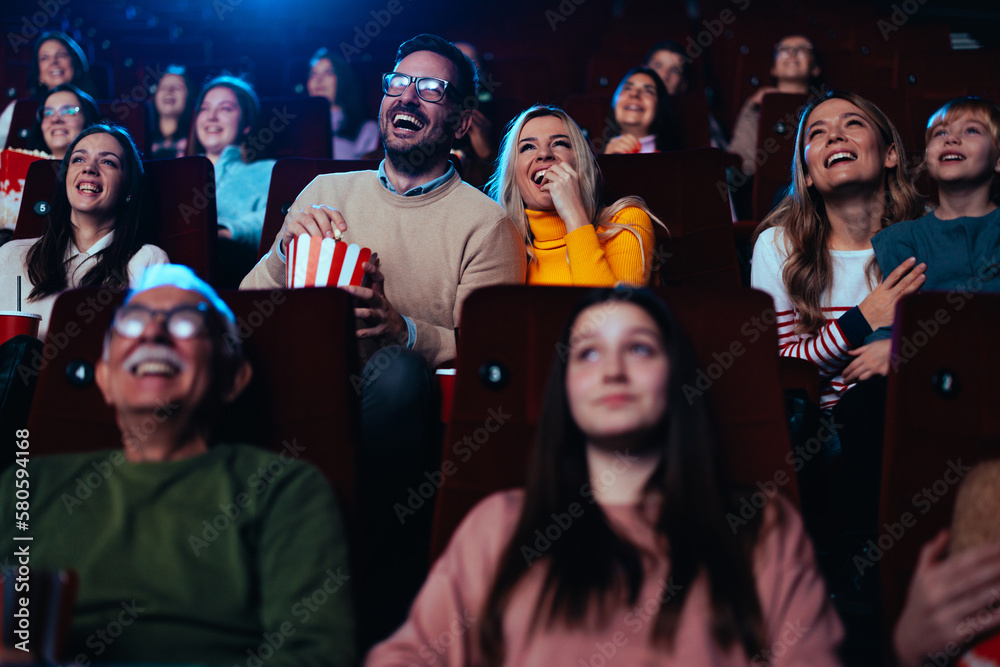Joyful couple watching funny movie in theater.