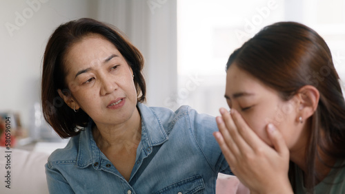Middle aged asia people old mom love care trust comfort help young teen talk crying stress relief at home. Mum as friend listen adult child woman feel pain sad worry of broken heart life crisis issues © ChayTee