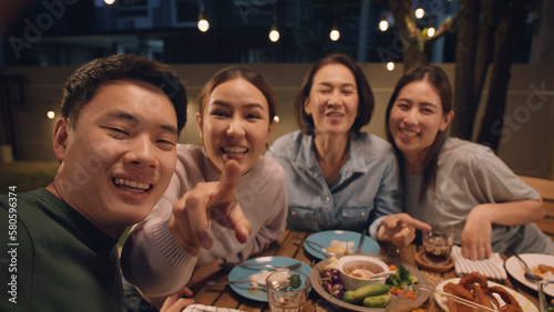 POV webcam screen group facetime videocall look at camera greeting smile laugh fun joy talk online at dine table night party at home. Enjoy mobile phone selfie app with young senior middle aged mom.