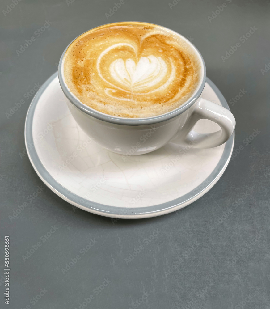 Top view of espresso cup with heart-shaped foam on gray background Top view of espresso cup with heart-shaped foam on gray background
