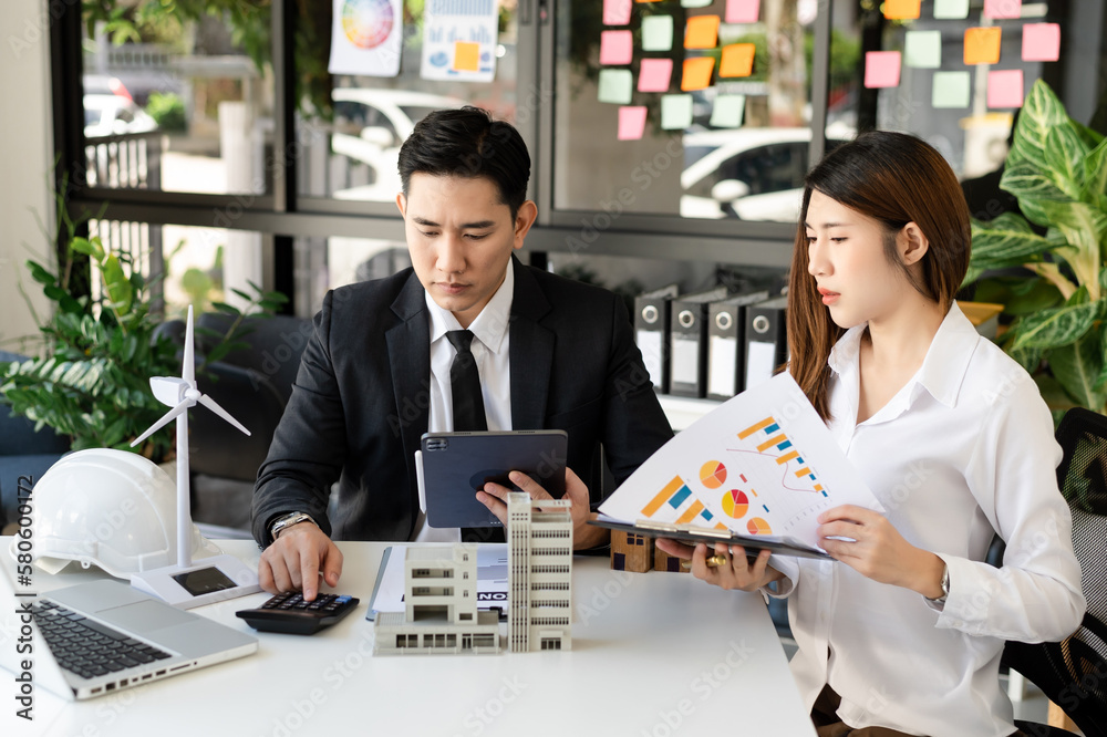 Fototapeta premium Buying a home or insurance deal, an insurance agent pointing a pen to those interested in renting a house, a contract, signing an Home buying agreement in office.