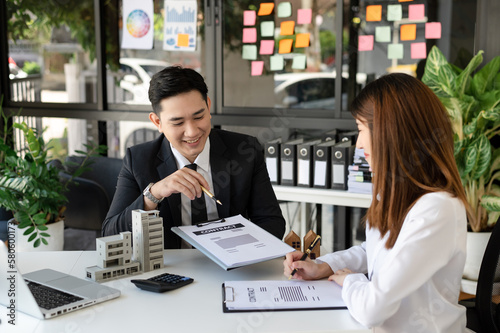 Fotografía Buying a home or insurance deal, an insurance agent pointing a pen to those interested in renting a house, a contract, signing an Home buying agreement in office