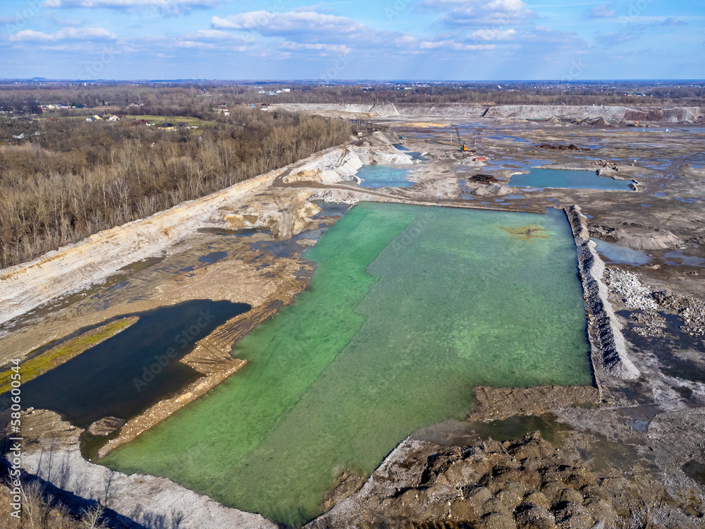 Aerial view landscape. Blue lake, pond, water. Excavators and machinery.