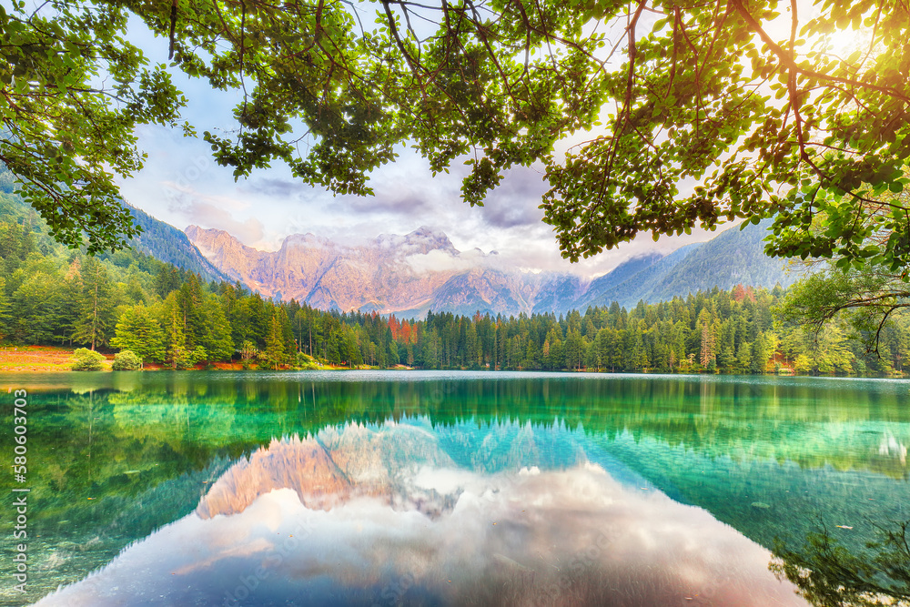 Incredible view of sunset over Fusine lake with Mangart peak on background.