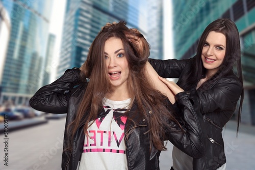 Happy young woman friends posing on street