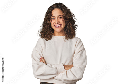Radiant young woman with stunning curls who feels confident, crossing arms with determination.