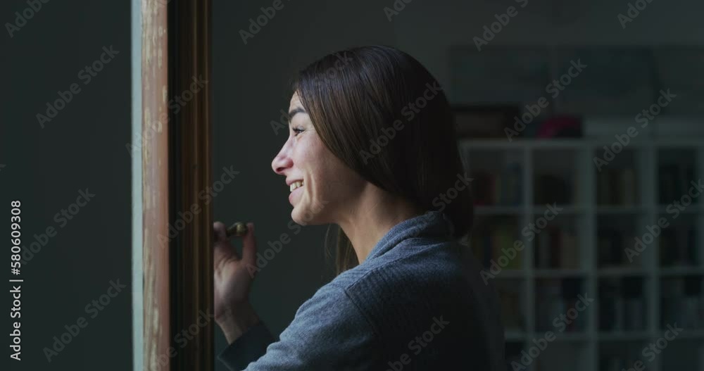 Portrait of a Female Opening a Window at Home to Talk to a Passing by Friend or Family. Woman Waving at her Neighbors, Being Friendly. She is Talking and Chatting with them, Asking about Their News Portrait of a Female Opening a Window at Home to Talk to a Passing by Friend or Family. Woman Waving at her Neighbors, Being Friendly. She is Talking and Chatting with them, Asking about Their News