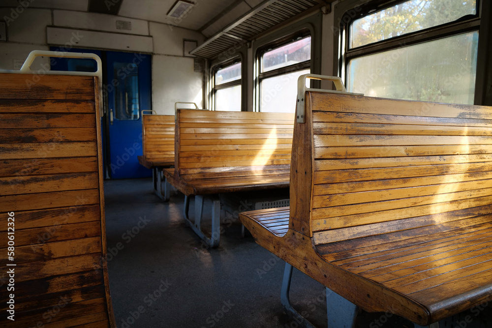 Old empty wagon of train. Wooden seats in an empty coach of train