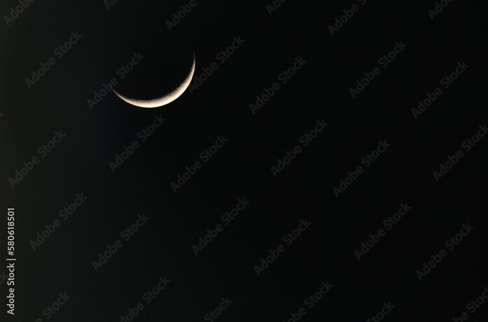 A crescent moon with black sky in background A crescent moon with black sky in background