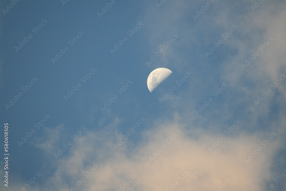 Half moon with blue sky and white clouds on background Half moon with blue sky and white clouds on background