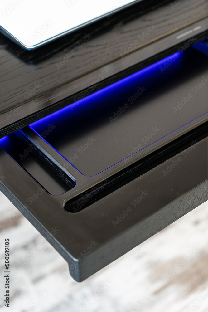 Top view of empty open wooden drawer office table with blue lightning. Modern office table with light Top view of empty open wooden drawer office table with blue lightning. Modern office table with light