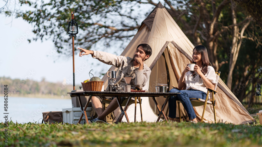 Obraz premium Asian couple camping outdoors. Couple travelers holding hands together love and Travel Lifestyle.