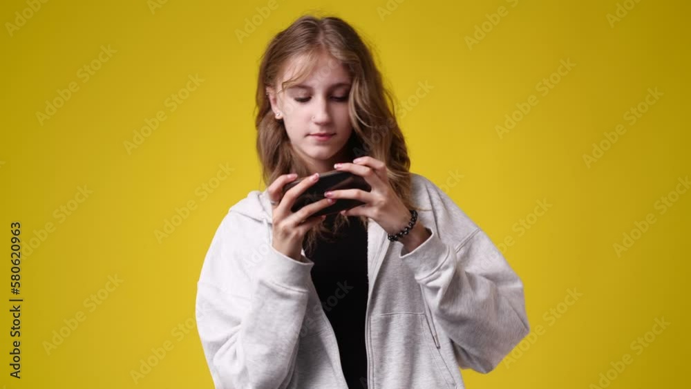 4k video of one girl sending messages on yellow background. 4k video of one girl sending messages on yellow background.