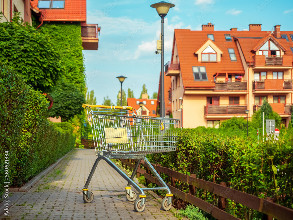 Fototapeta premium empty trolley shopping cart outside near apartment house entrance