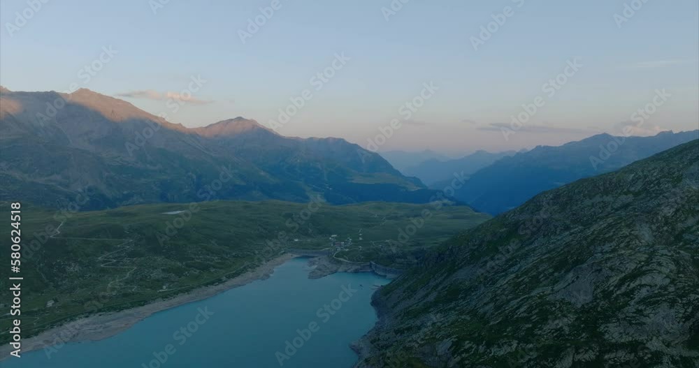 Aerial shot over a lake with mountains on the horizon at sunset in montespluga, Lombardy. Aerial shot over a lake with mountains on the horizon at sunset in montespluga, Lombardy.