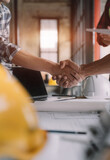 architects and engineers shake hands while working for teamwork and cooperation after completing an agreement in an office facility, successful cooperation concept.