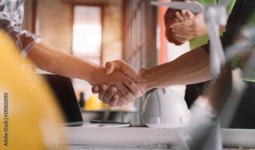 architects and engineers shake hands while working for teamwork and cooperation after completing an agreement in an office facility, successful cooperation concept.