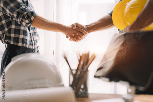 Fotografie Construction workers, architects and engineers shake hands while working for teamwork and cooperation after completing an agreement in an office facility, successful cooperation concept