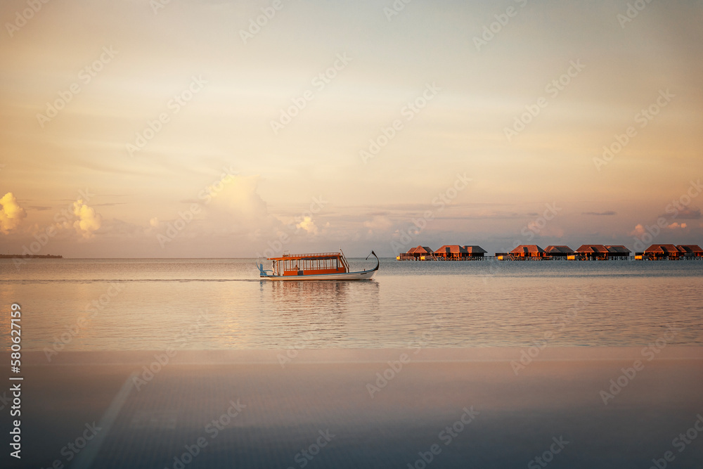 Naklejka premium boat on the sea at sunset