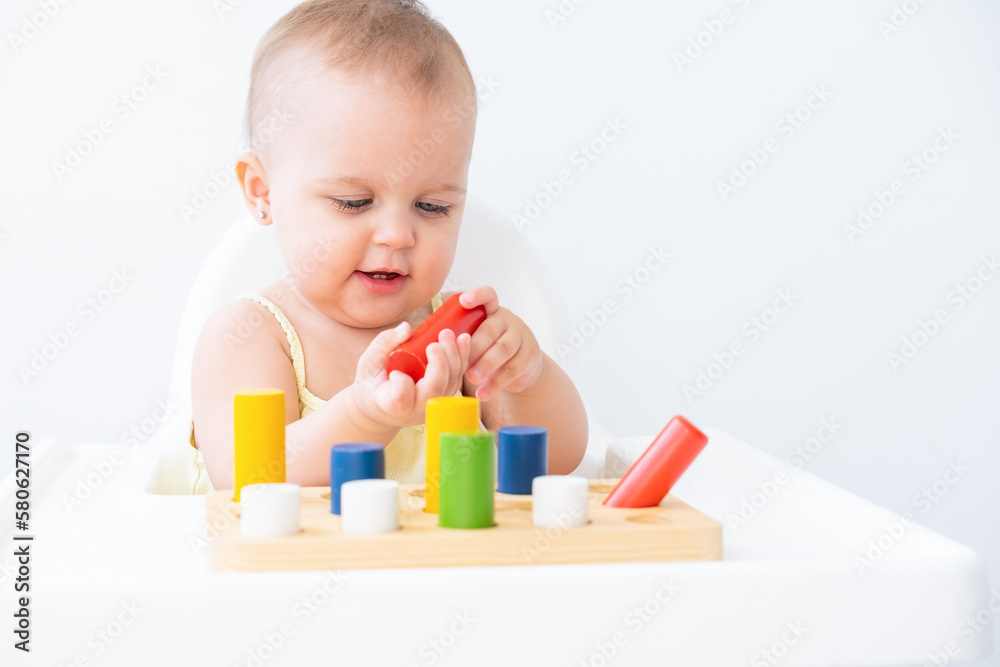cute baby girl playing with colorful wooden blocks at child chair. early children development cute baby girl playing with colorful wooden blocks at child chair. early children development