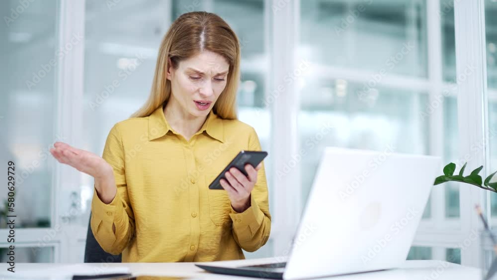 Nervous blond mature business woman has problem issues with smartphone bad service at workplace Stressed entrepreneur using mobile with no connection signal error mistake with app application indoors