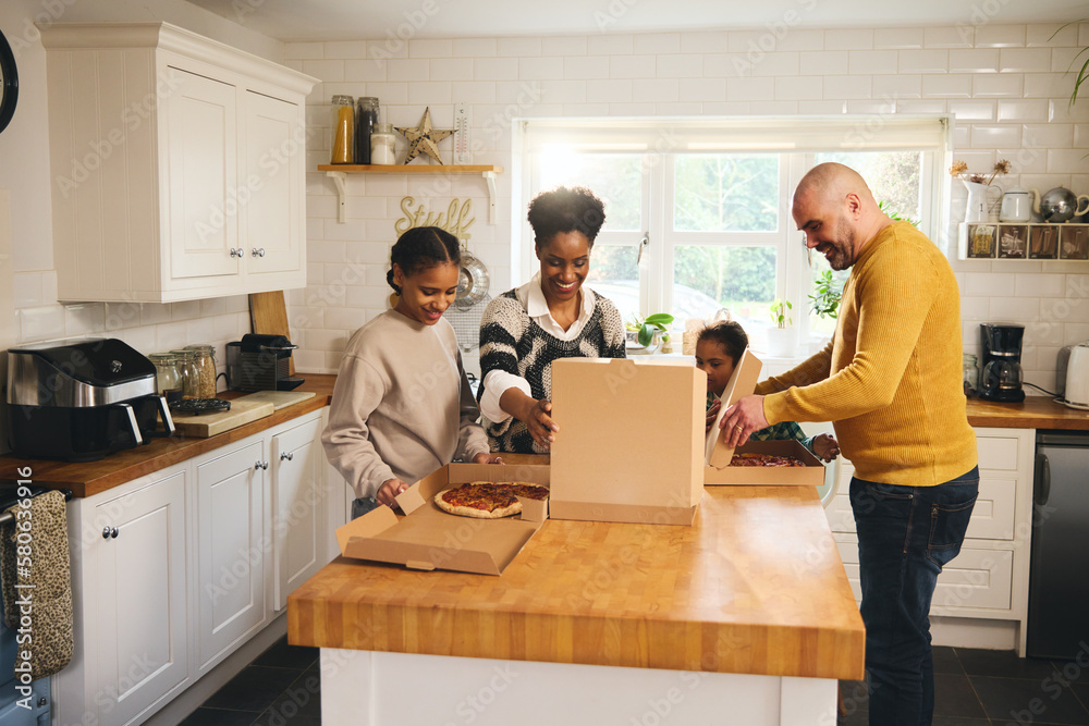 Family serving takeaway pizza for dinner in kitchen Family serving takeaway pizza for dinner in kitchen