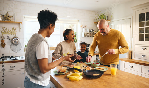 Family and boy with Down syndrome making pancakes for breakfast
