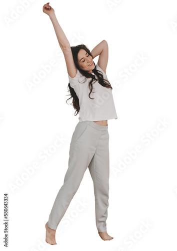 Young adult brunette hispanic woman in casual stands against transparent background stretching enjoying weekend. Relaxed caucasian girl eyes closed awakening. Vertical shoot of fit healthy housewife.