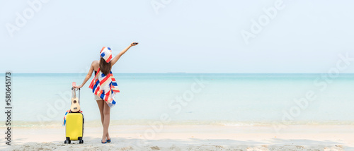 Summer vacations. Lifestyle woman relax and chill on beach background. Asia happy young people with bag travel suitcase luggage fashion dress raise arm wave sea, summer trips travel