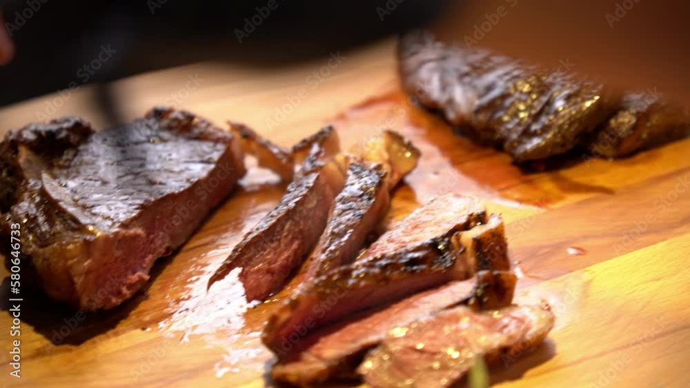 Chef cuts beef steak on a wooden board, close-up. Selective focus Chef cuts beef steak on a wooden board, close-up. Selective focus