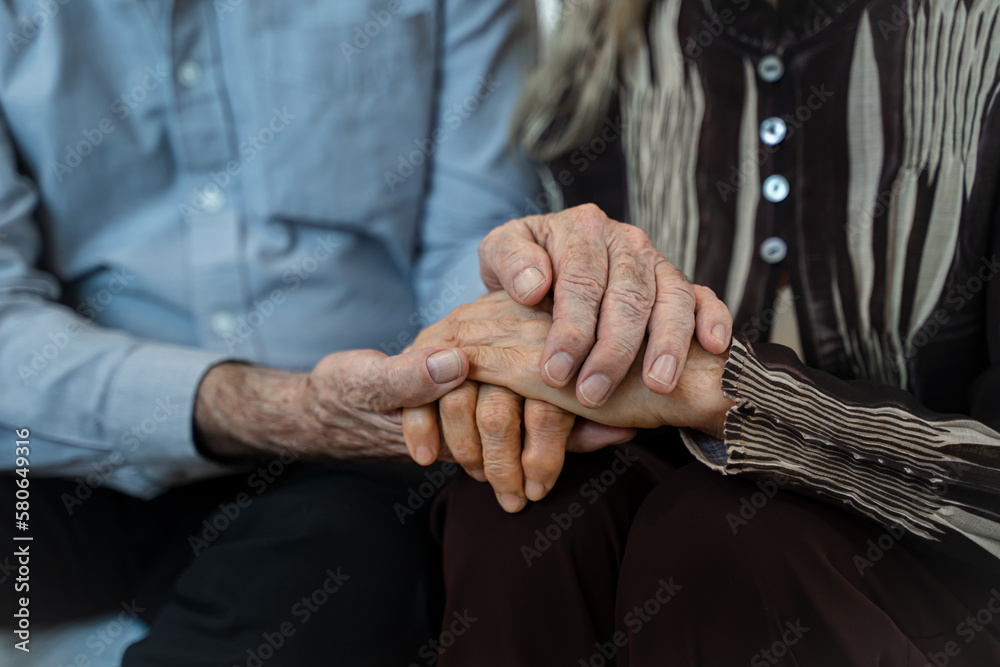 Close up mature spouses holding hands,Support,Couple hands holding in love and comfort together in the hope of unity.
