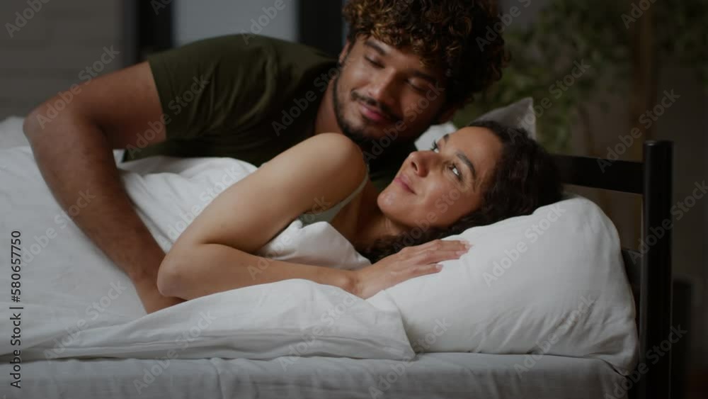 Family love and unity. Caring young middle eastern guy hugging his sleepy girlfriend in bed, falling asleep together Family love and unity. Caring young middle eastern guy hugging his sleepy girlfriend in bed, falling asleep together