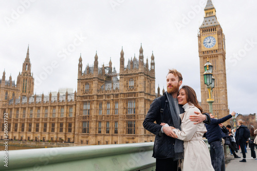 Canvas Print Happy couple of young travelers embrace against the background of London's Big B