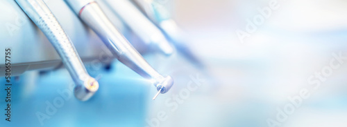 Closeup photo of dental handpieces and equipment on dental chair with blured background.
