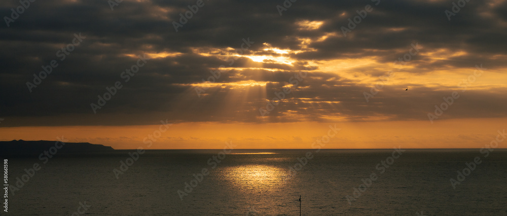 Coastal sunset with clouds and golden sky